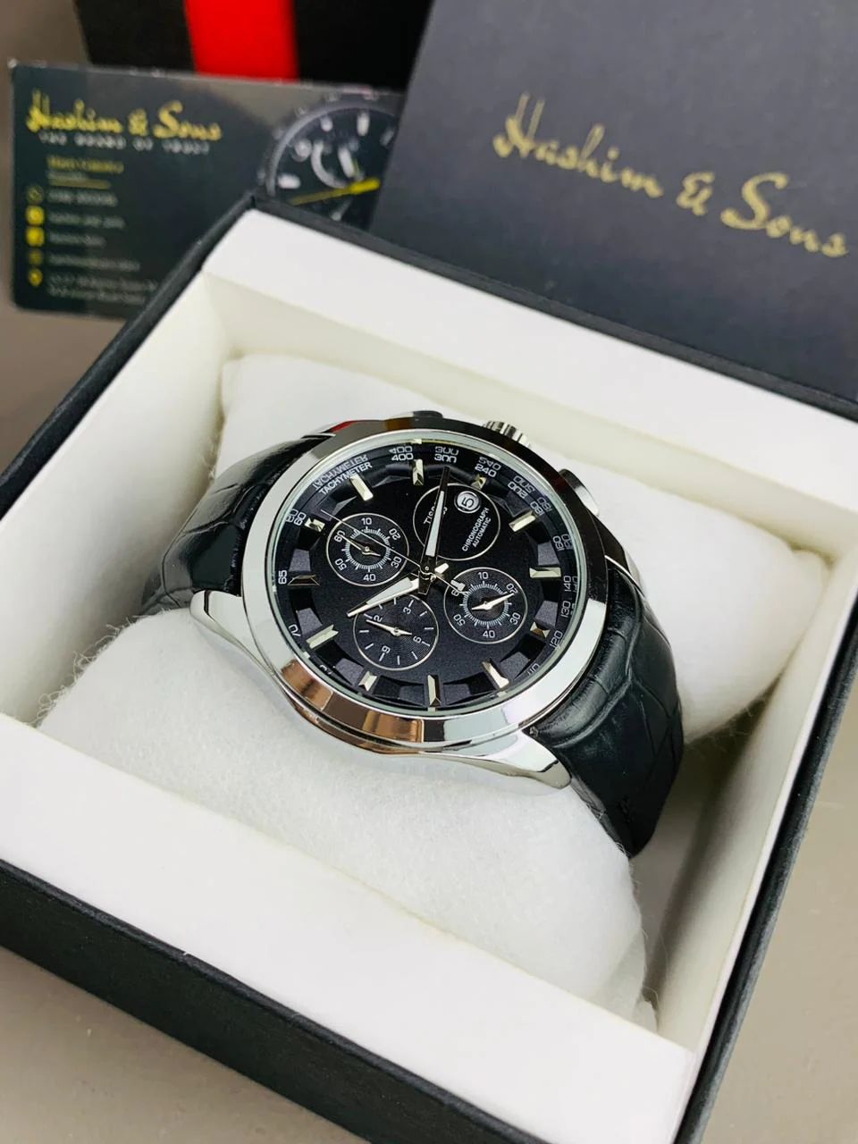 chronograph-style timepiece with a white dial and gold-tone accents.