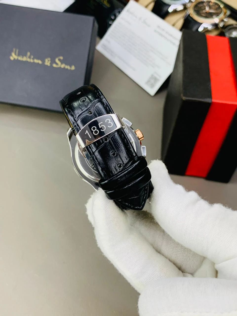 chronograph-style timepiece with a white dial and gold-tone accents.