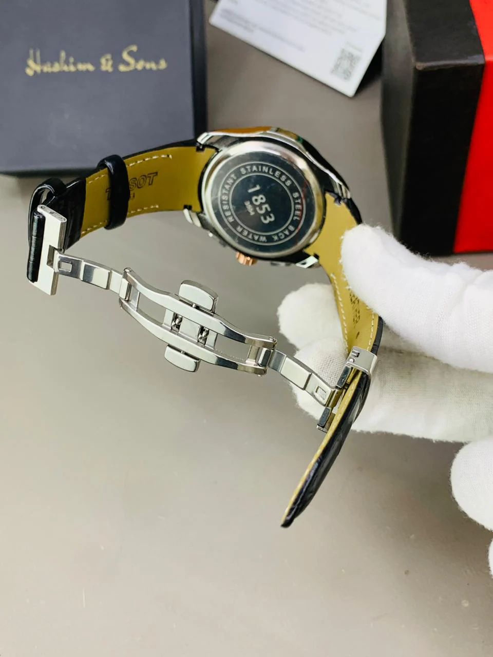 chronograph-style timepiece with a white dial and gold-tone accents.